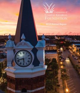 Clock tower at sunset with city street lit below.
